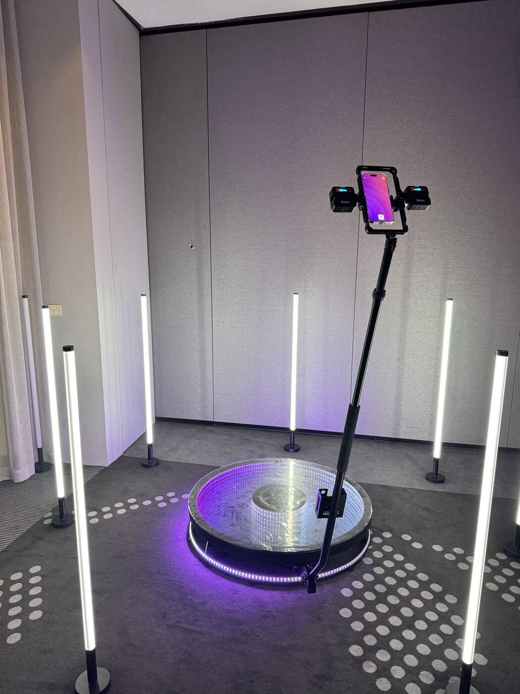 360 photo booth LED platform and camera arm set up with tube lighting at an event venue